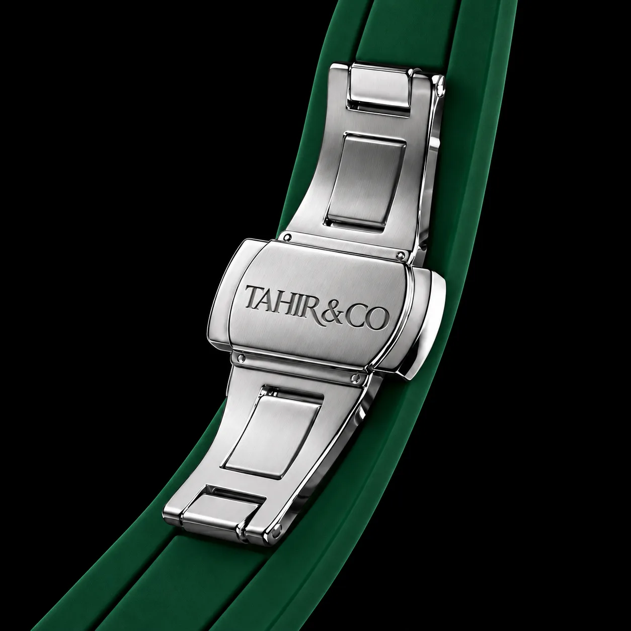 Steel deployant clasp engraved TAHIR & CO on the green strap